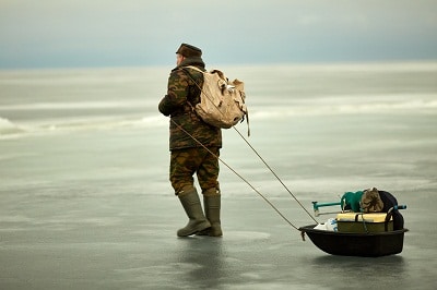 ice fisher dragging sled