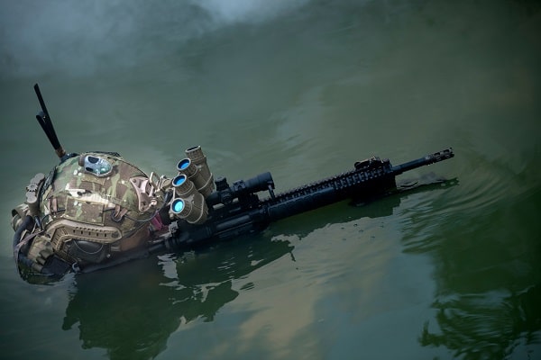 A soldier wearing night vision goggles operating in water