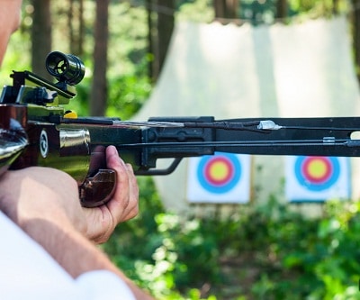 Man aiming crossbow at target