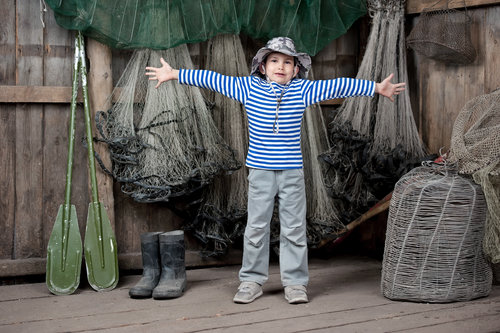 a boy in front of fishing nets