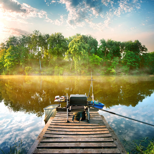 Fishing a calm river in the morning on a dock