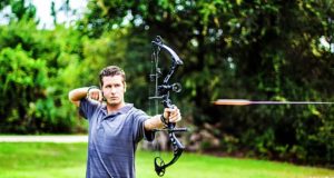 man shooting compound bow