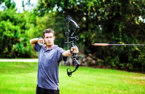 man shooting compound bow
