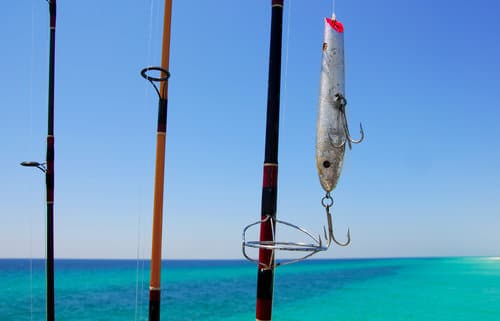 fishing poles and a lure near ocean