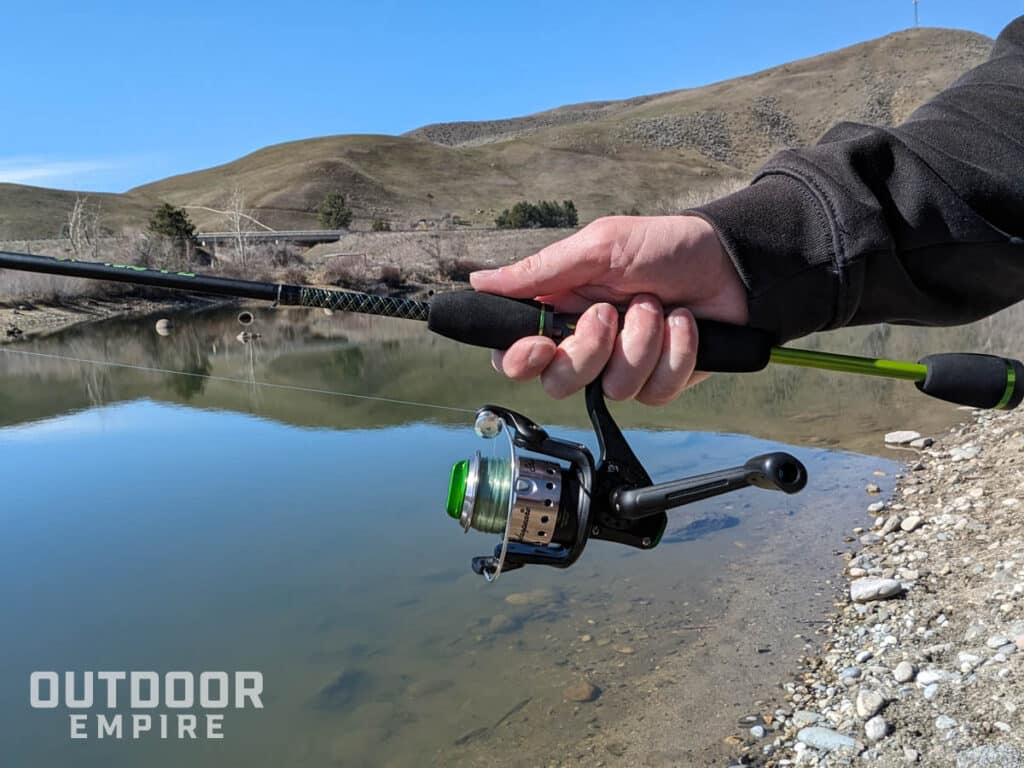 Hand holding fishing rod with spinning reel