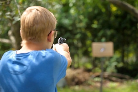 Boy shooting airgun pistol