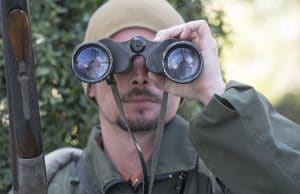 Hunter looking through binoculars