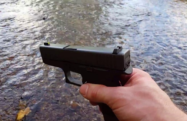 man holding Glock 43 with sight