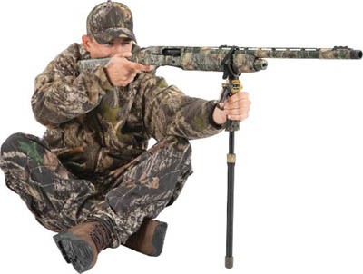Man aiming rifle with shooting stick