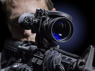 A person aiming through night vision scope