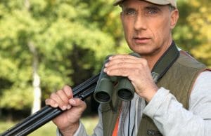 Hunter with a shotgun and pair of binoculars