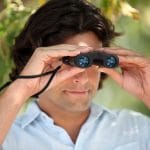 Man looking through compact binocs