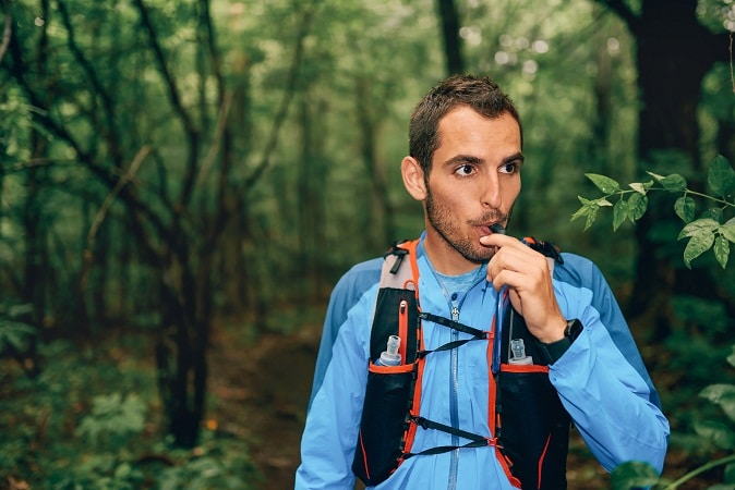 hiker sipping through tube of best hydration pack