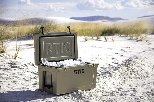 Open cooler with ice and drinks on beach