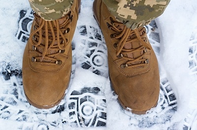 pair of legs in brown military boots