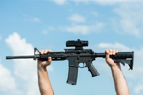 both hands holding AR-15 up the sky