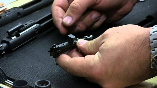hands assembling rifle bolt