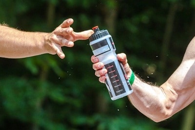 hands passing water bottle