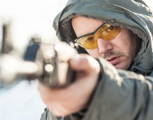 man aiming a rifle