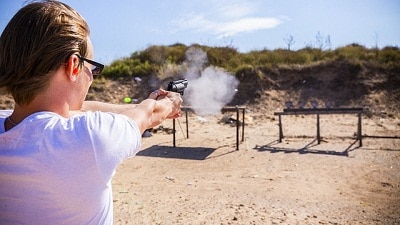 man practice shooting in an open field