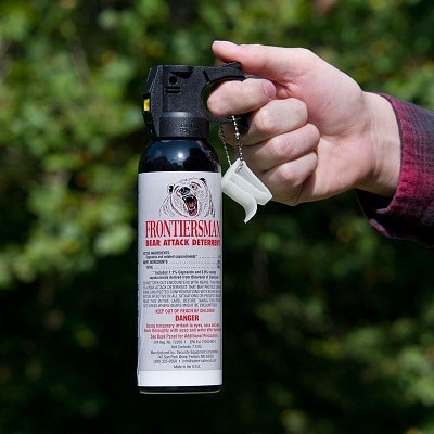 hand holding bear spray without safety clip