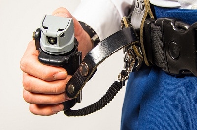 Hand holding Pepper spray with flip-top safety