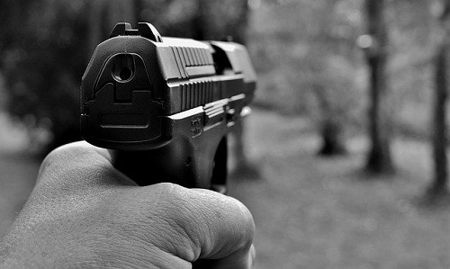 handgun aimed at the forest