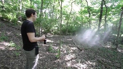 Man using bear spray in the forest