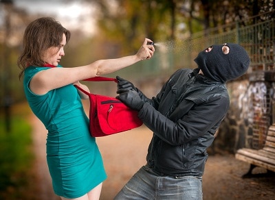 woman using pepper spray on a thief