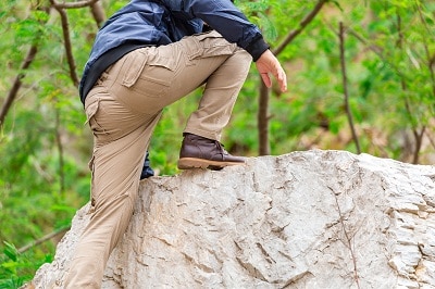 Man wearing cargo pants climbing on the rock