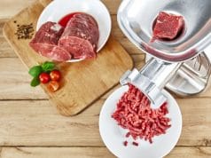 Fresh forcemeat cutting board with Meat grinder on kitchen table