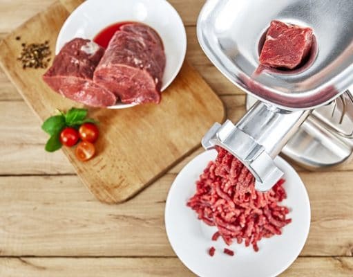 Fresh forcemeat, cutting board with Meat grinder on kitchen table