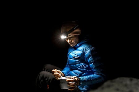 camper eating with headlamp in pitch black