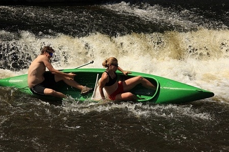 couple in tilted canoe on rough waters