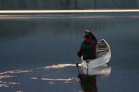 man canoeing on still water