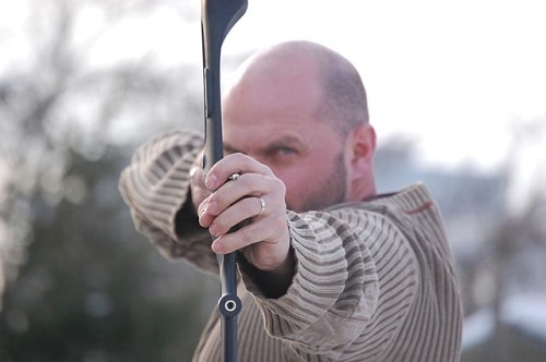 man holding recurve bow