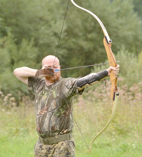 man hunting with recurve bow