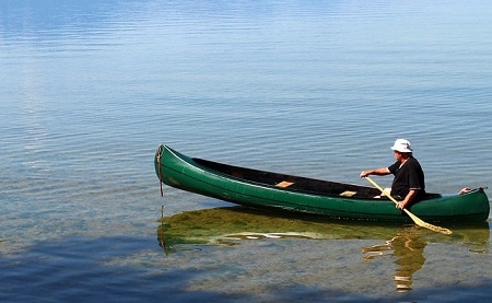 man paddling moderate rocker canoe