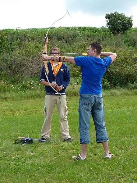 man training with recurve bow in the field