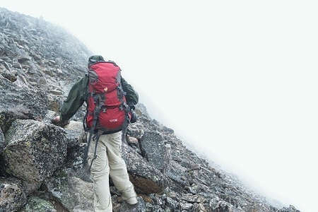 backpacker hiking a rocky mountain slope