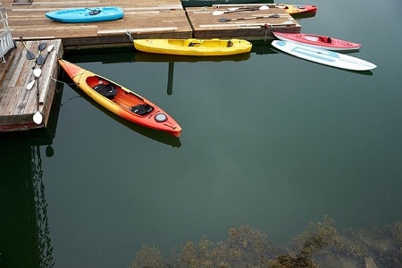 empty kayaks parked by a dock