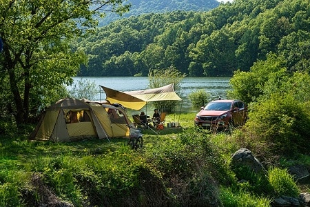 family camping in the woods with car parked