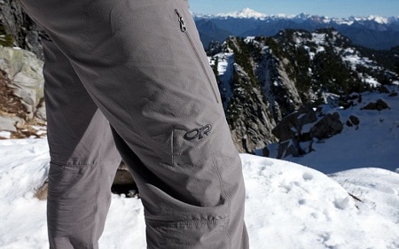 hiker legs upclose on a snowy cliff