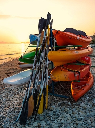 kayaks and paddles stacked on rack