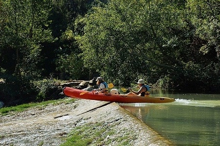 ladies paddling kayak on a dam