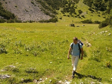 man hiking on a grassland during a sunny day