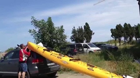 man loading kayak on his car roof
