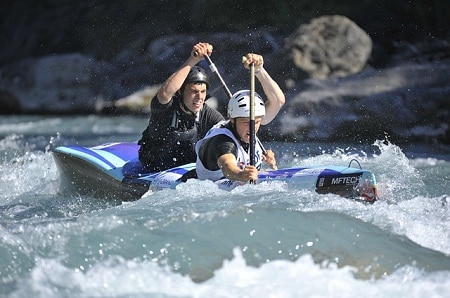 men paddling tandem kayak for water rafting