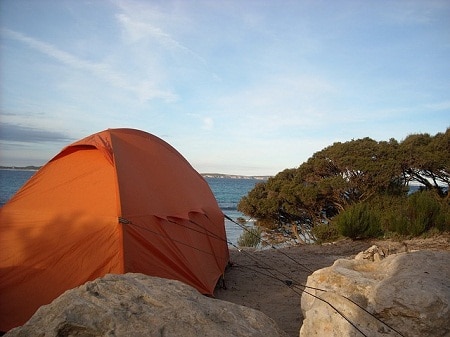 tent tied on rocks by the shore
