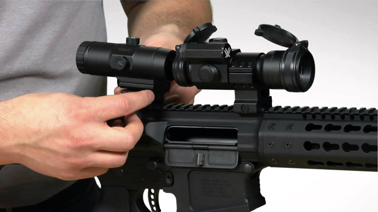 man assembling magnifier on rifle